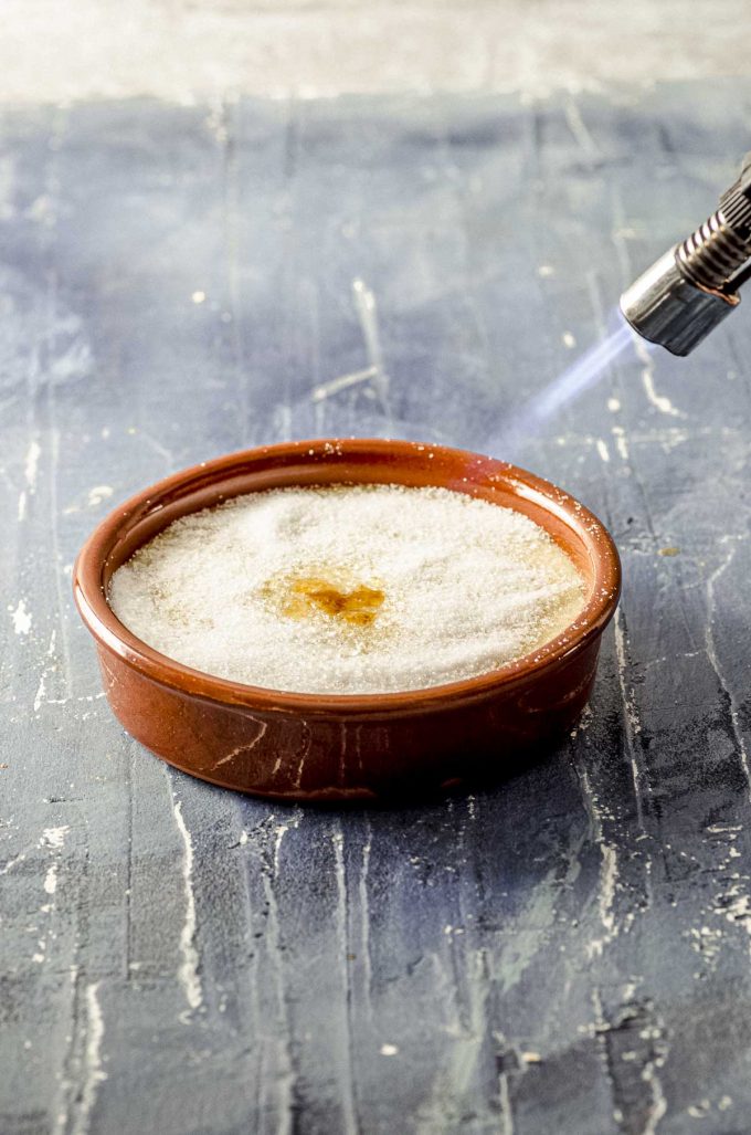 Torching sugar on top a cooled Crema Catalana