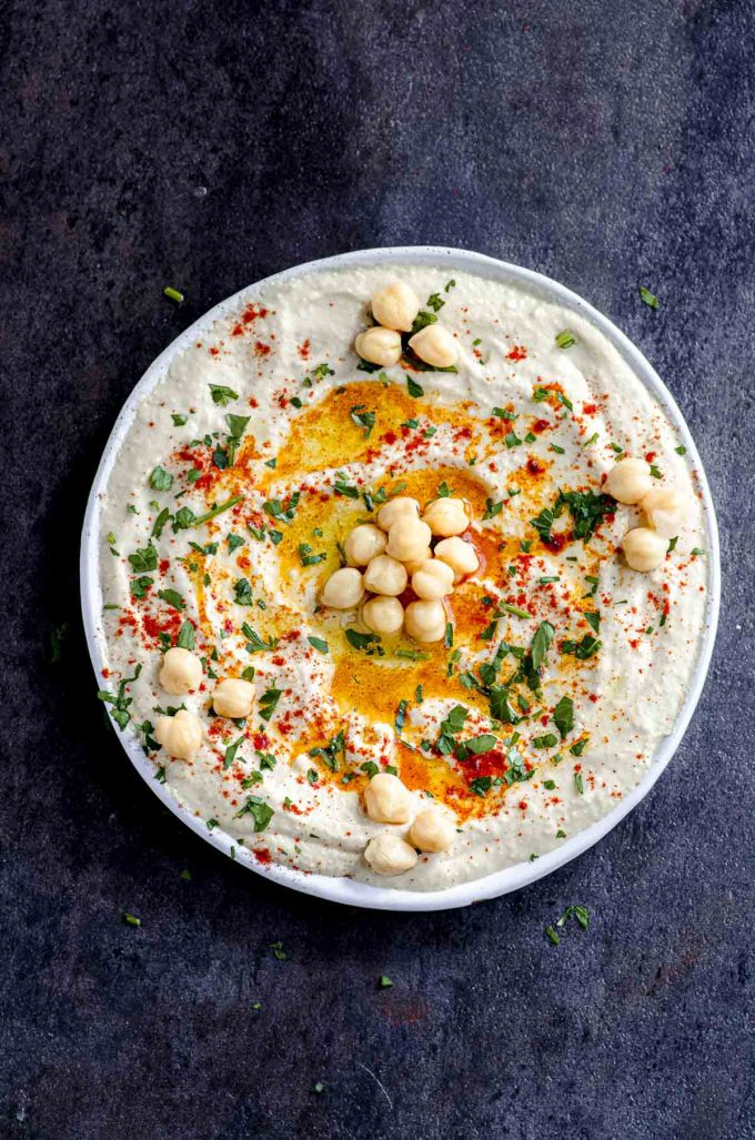Hummus plate with olive oil, paprika, chickpeas, and chopped parsley