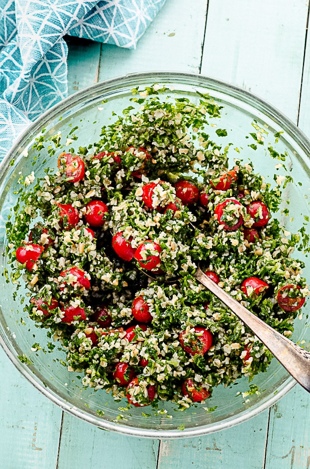 A clear serving bowl filled with tabbouleh salad