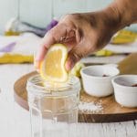 Squeezing a lemon slice into a jar