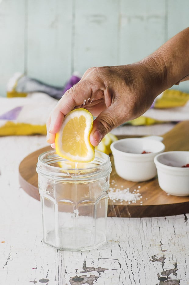 Squeezing a lemon slice into a jar