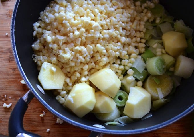 In a soup pot, corn kernel, sliced leeks and potatoes
