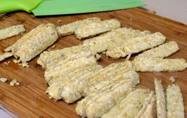 A wood cutting with sliced tempeh