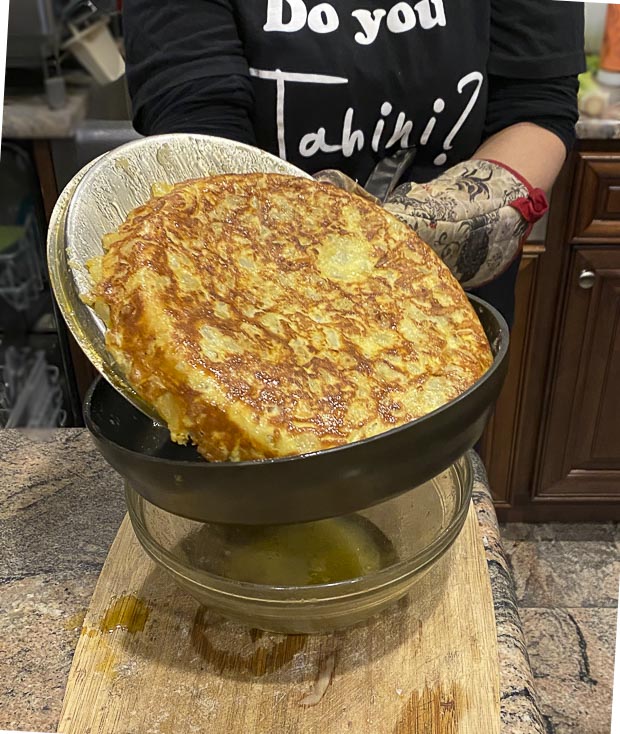 Slide the flipped tortilla de patatas back into the skillet