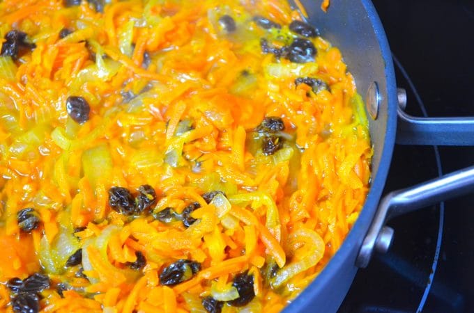 A pan with onions carrots and rainins to make a basmati rice