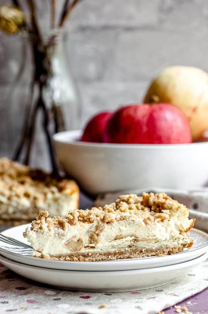A slice of apple pie cheesecake on a plate