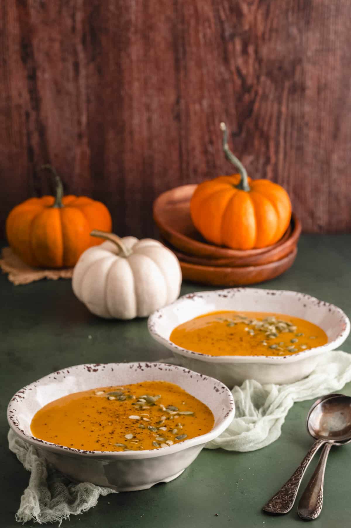 Close up side view of two bowl of pumpkin soup