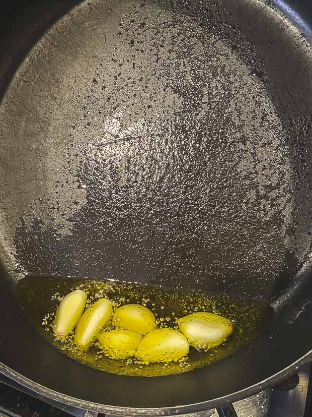 Garlic cooking in olive oil to make cranberry beans