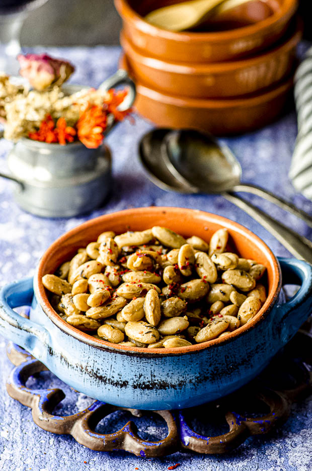 Close up view of a blue ceramic bowl filled with cooked cranberry beans