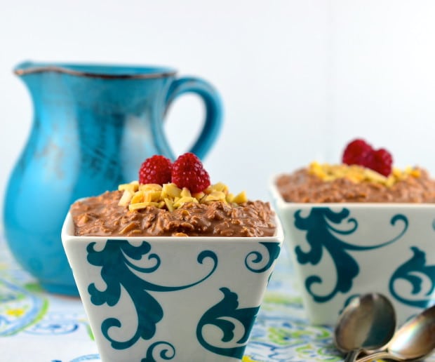 Two bowls filled with peanut butter overnight oats topped with  crushed peanuts and raspberries
