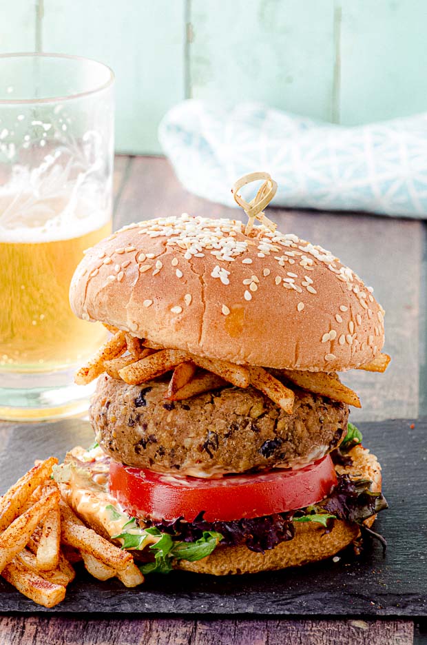 Close up view of a tempeh and black bean veggie burger on a bun