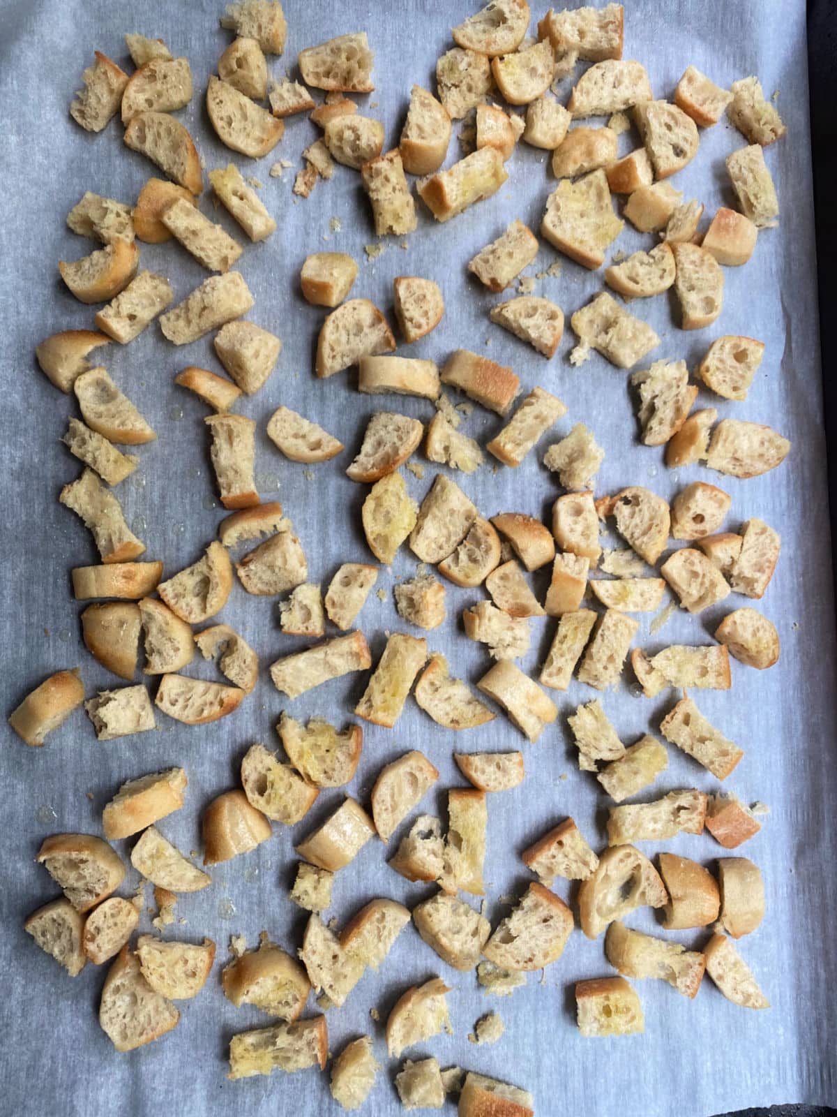 French bread cut into crouton on a baking sheet
