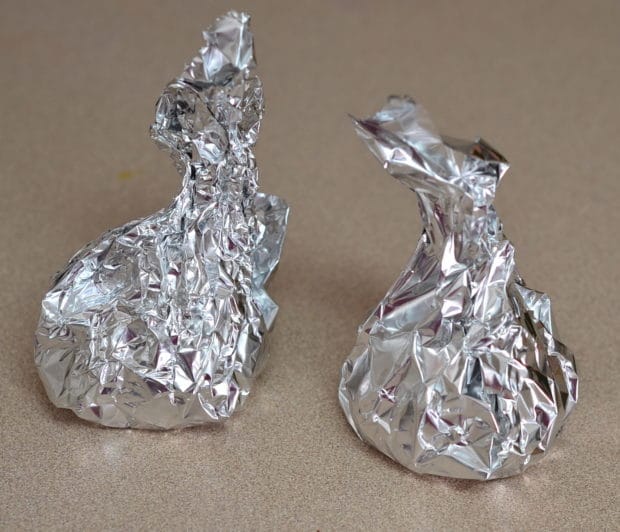 two heads of garlic wrapped in aluminum foil
