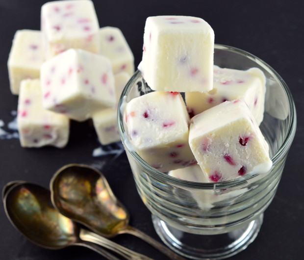 Close up of Frozen Greek Yogurt and Pomegranate Bites (Cubes) stacked inside a clear glass