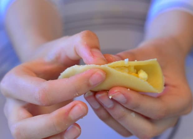 pinching the edges of  borekas filled with cheese