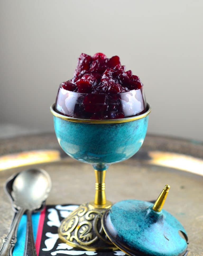 A blue serving cup with pear wine and cranberry chutney