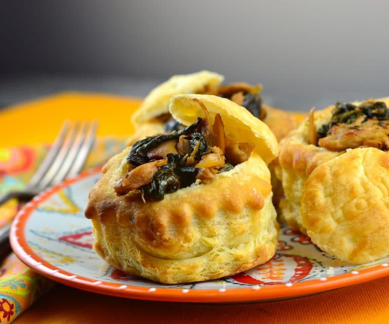 A side view of 3 vol au vents filled with seitan and herbs
