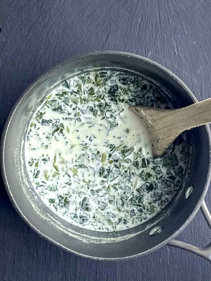 Mixing milk, spinach and semolina flour in a saucepan
