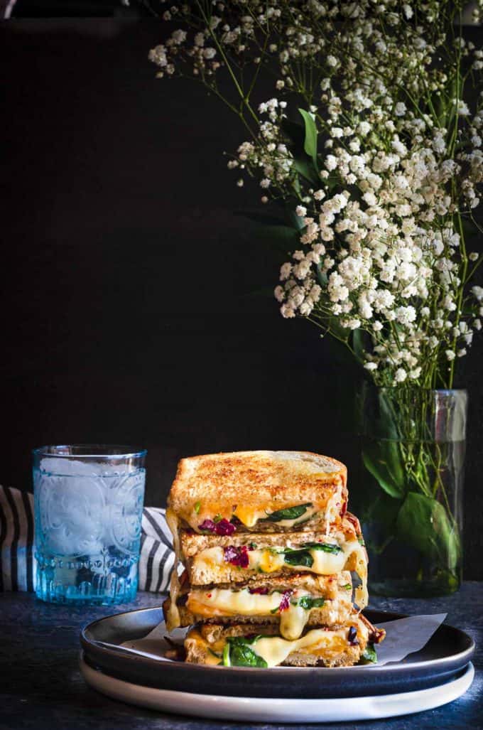 The best grilled cheese sandwich on plates with a vase of babys breath next to it