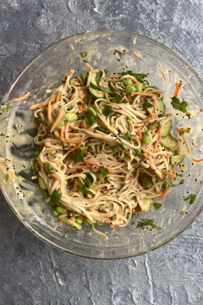 Soba noodles with ginger dressing mixed in a glass bowl