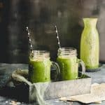 Side view of two green smoothies on a metal tray
