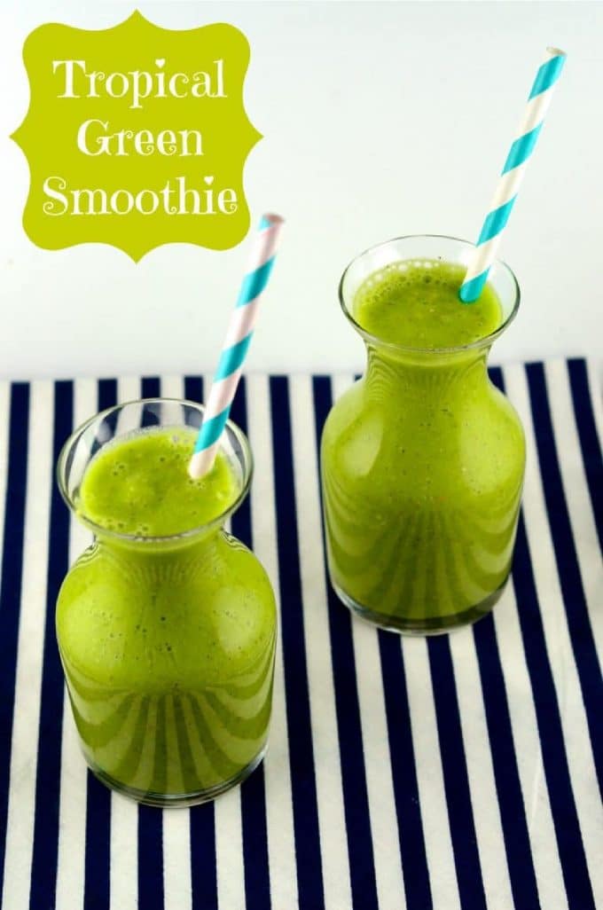 two bottles with green smoothie on a navy and white stripped surface
