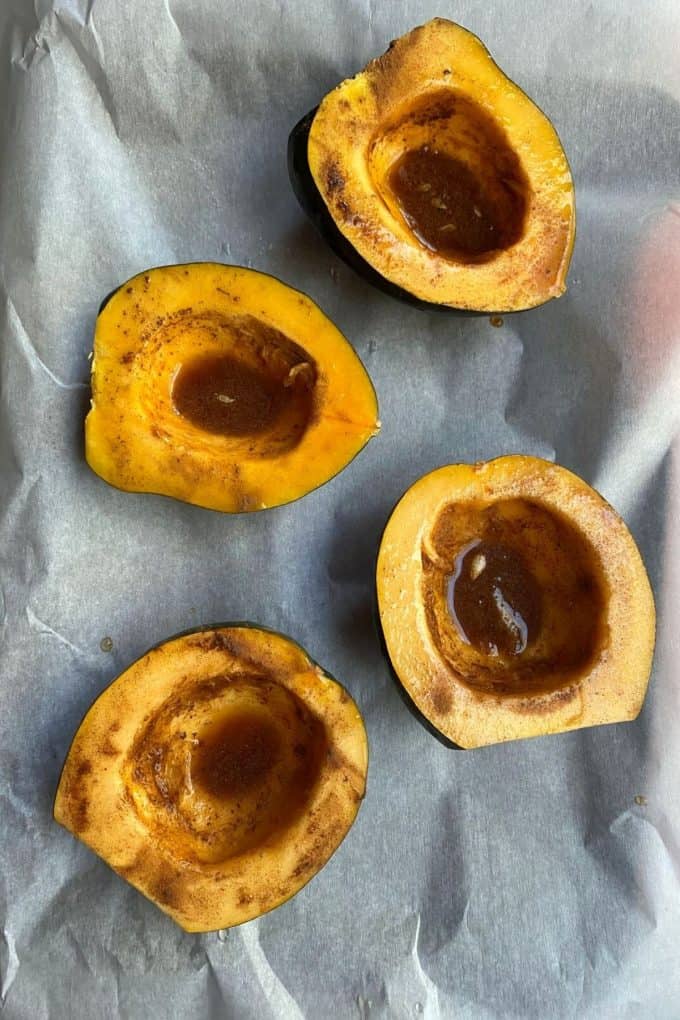 An overhead view of halved acorn squash with maple syrup and cinnamon micture