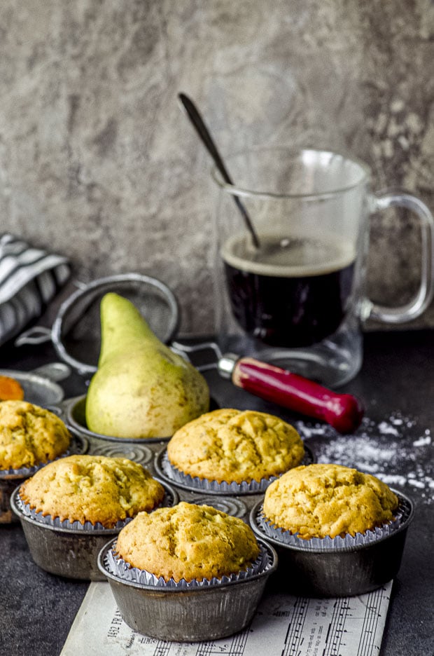 Side view of a muffin tin with six Ginger, Pear & Turmeric Muffins