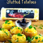 Bite size cheese stuffed potatoes on a wood board with a block of chipotle cheese in the background