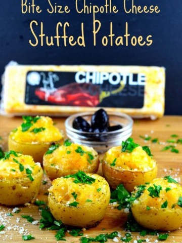 Bite size cheese stuffed potatoes on a wood board with a block of chipotle cheese in the background