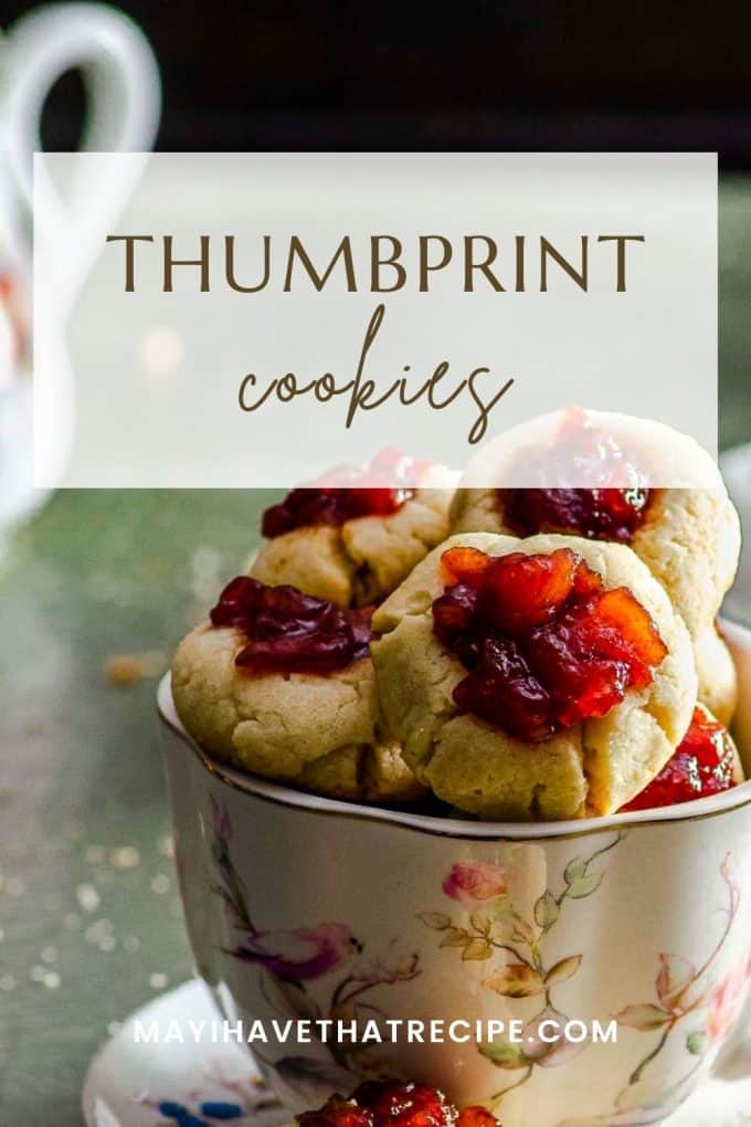 A close up of a tea cup style mug filled with thumbprint cookies