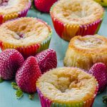 Side view of strawberry banana muffins on a green wood surface