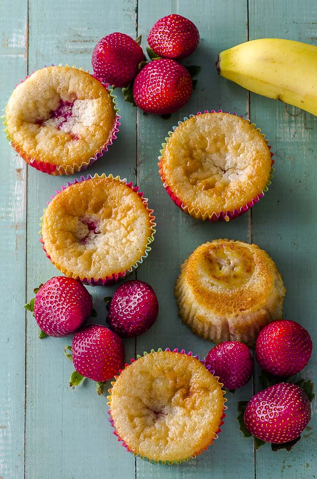 overhead view of strawberry banana muffins on a green wood surface