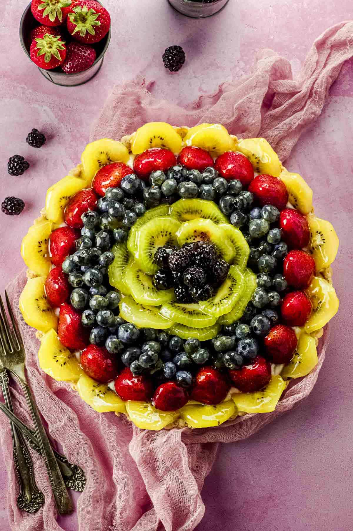 Close up view of a fruit tart with a pink background