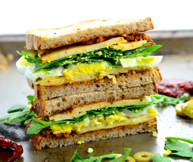 Crunchy Tomato Olive Cheese Vegetarian Picnic Sandwich - home made sundried tomato spread , crunchy multigrain sour dough bread, creamy cheese, fresh arugula and satisfying egg.