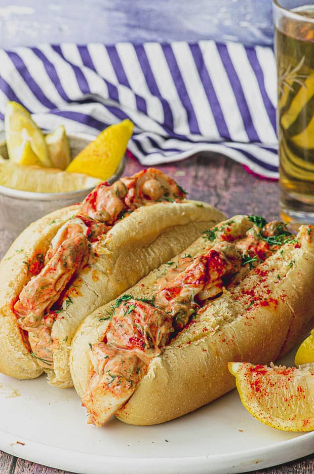 Side view of two vegan lobster rolls in a white plate