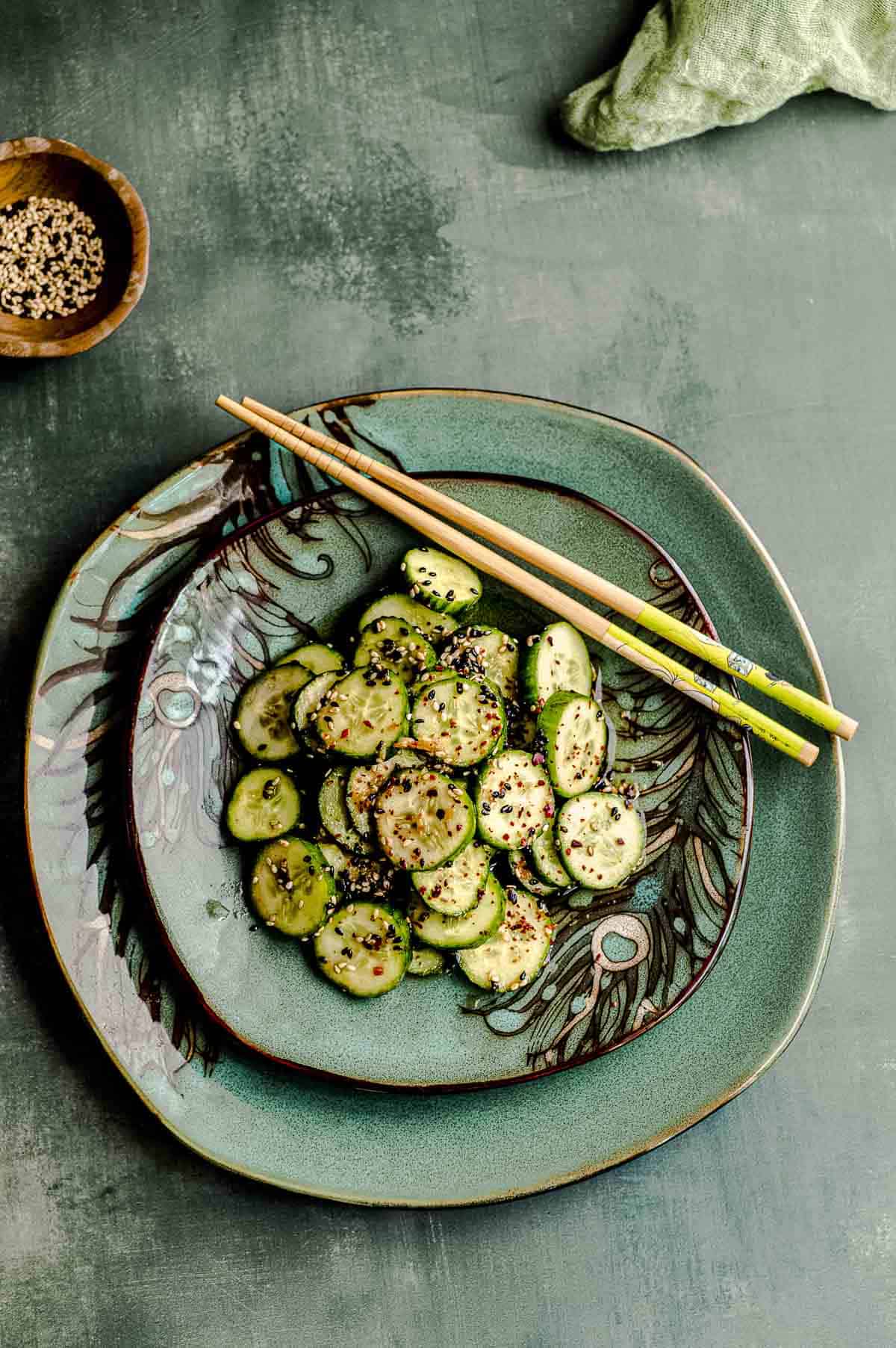 ovehead view of asian cucumber salad on two green plates, stacked