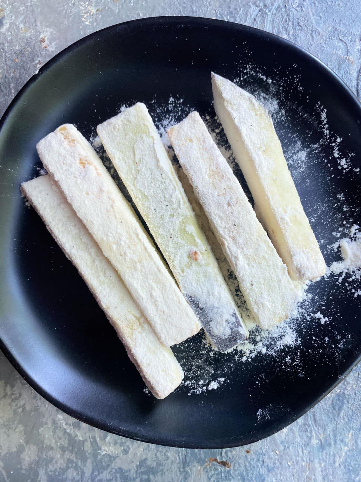 eggplant fries coated in flour in a plate