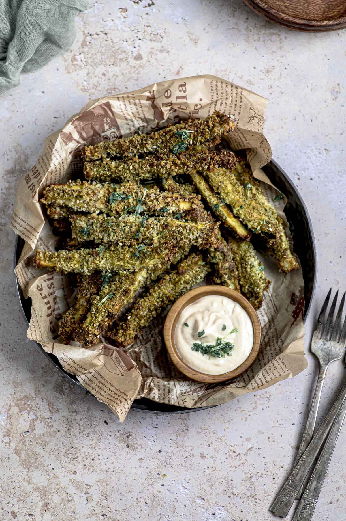 Zaatar eggplant fries in a plate with a small bowl of tahini sauce
