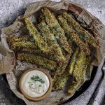 Close up view of a plate of eggplant fries with tahini sauce