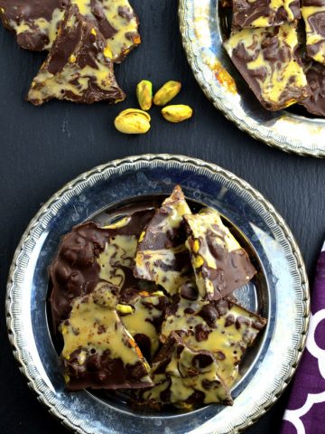 chocolate bark with pistachios on two silver plates