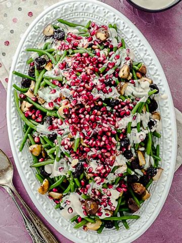 bid's eye vier of a serving dish with green beans with tahini and pomegranates