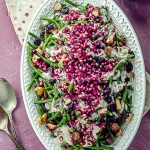 bid's eye vier of a serving dish with green beans with tahini and pomegranates