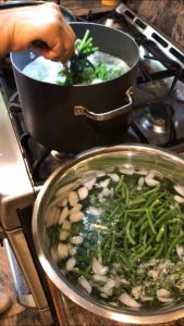 Placing cooked green beans in an ice water bath