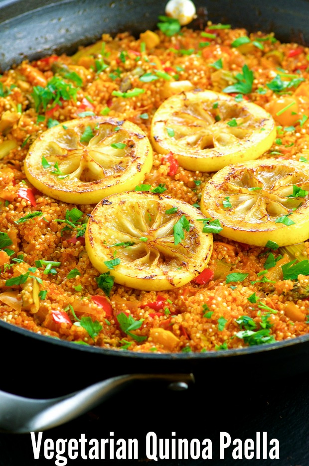 Close up of the Vegan Gluten Free Quinoa Paella garnished with four slices of roasted lemon in a paella pan