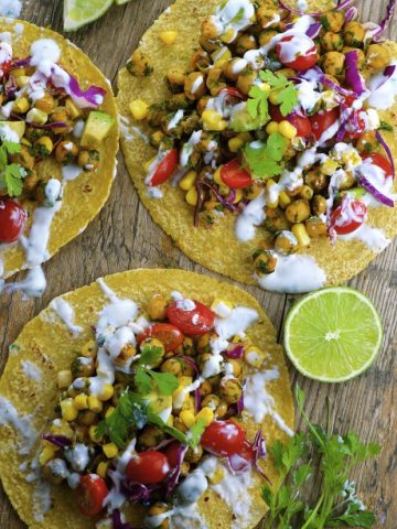 3 vegan chickpea tacos on a wood board