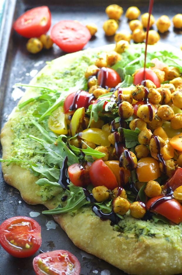 Topped with creamy cashew basil ricotta, arugula, tomatoes and spiced chickpeas and drizzled with a tangy pomegranate reduction, this Cashew Ricotta Pizza is like summer on a plate!