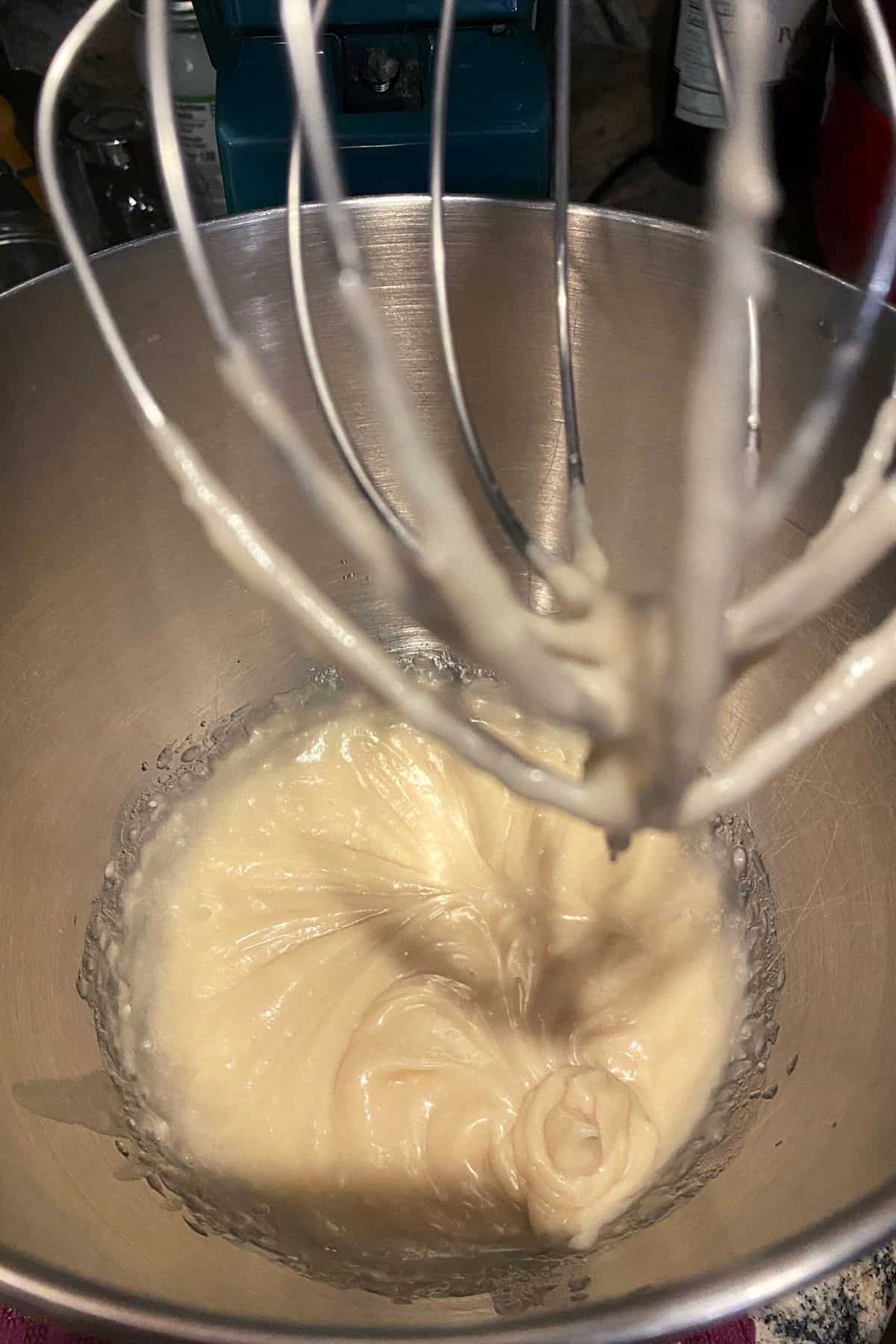 A close up view of blueberry cornbread muffin batter in a mixer