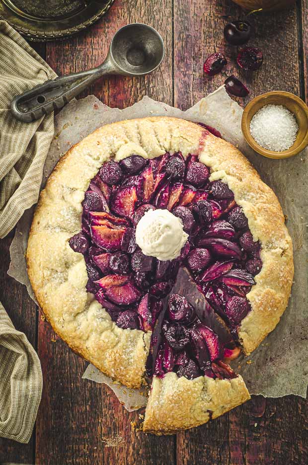 Bird's eye view of a fruit galette with some ice cream on top