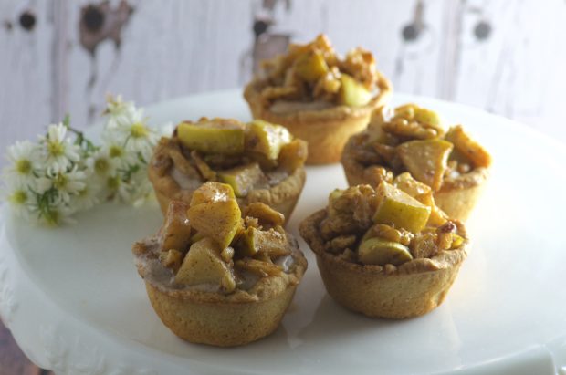 Bite Size Apple Pies, filled with sweet, rich cream cheese with a touch of cinnamon and maple syrup, topped with tart organic apples. The perfect little treat to welcome fall.